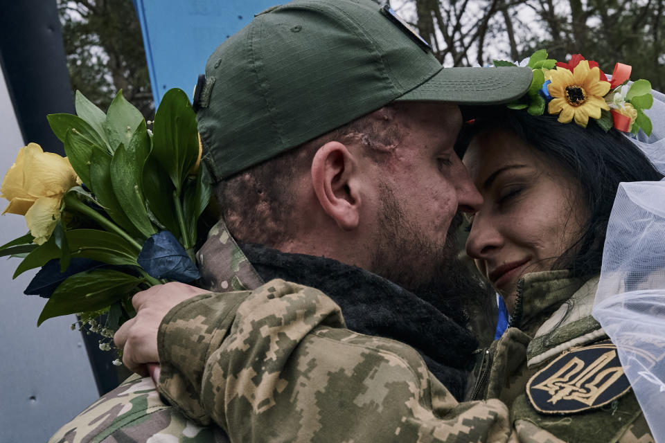 Ukrainian army medics Eugenia and Oleksander embrace after their wedding ceremony in Lyman, Donetsk region, Ukraine, Saturday, Dec. 24, 2022. (AP Photo/Libkos)