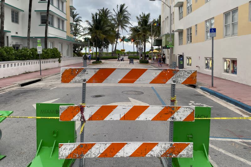 A barrier blocks a street prior to the 8 pm curfew in Miami Beach