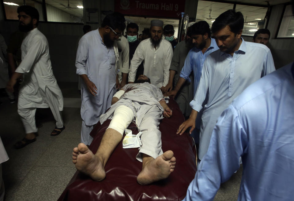 People transport an injured victim of a powerful bomb upon arrival at a hospital in Peshawar, Pakistan, Sunday, July 30, 2023. A bomb ripped through a rally by supporters of a hard-line cleric and political leader in the country's northwestern Bajur district that borders Afghanistan on Sunday, police and health officials said. (AP Photo/Muhammad Sajjad)