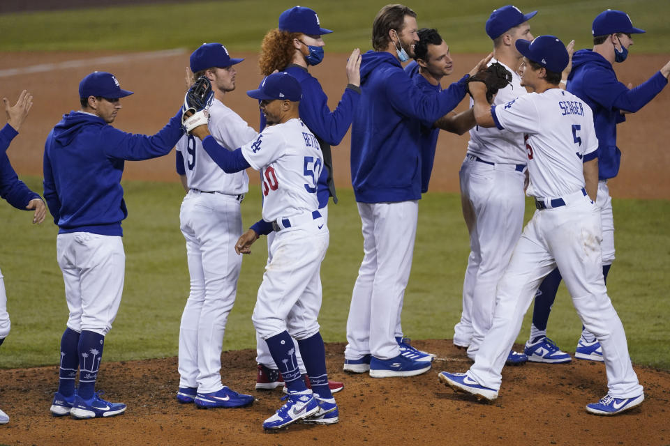 Los Angeles Dodgers right fielder Mookie Betts (50), shortstop Corey Seager (5) and teammates celebrate after the Dodgers clinched the NL West title with a 7-2 win over the Oakland Athletics in a baseball game Tuesday, Sept. 22, 2020, in Los Angeles. (AP Photo/Ashley Landis)