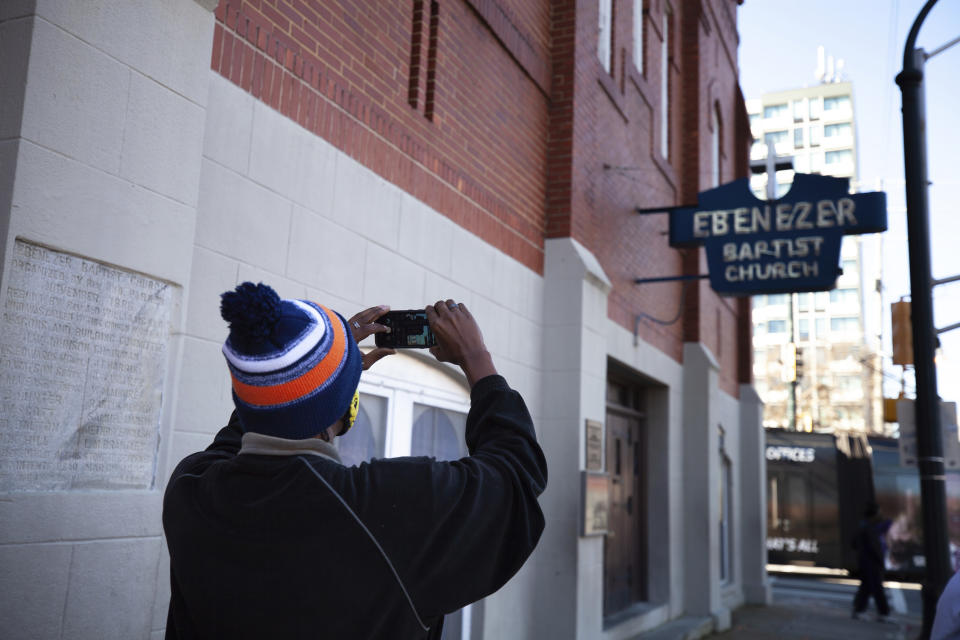 A man takes a photo of the Historic Ebenezer First Baptist Church where Martin Luther King Jr. preached on Monday, Jan. 18, 2021, in Atlanta. (AP Photo/Branden Camp)