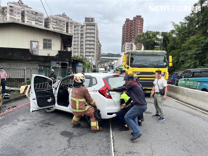 警消協力以人力抬車方式，先清出一個車道疏導車流。（圖／翻攝畫面）