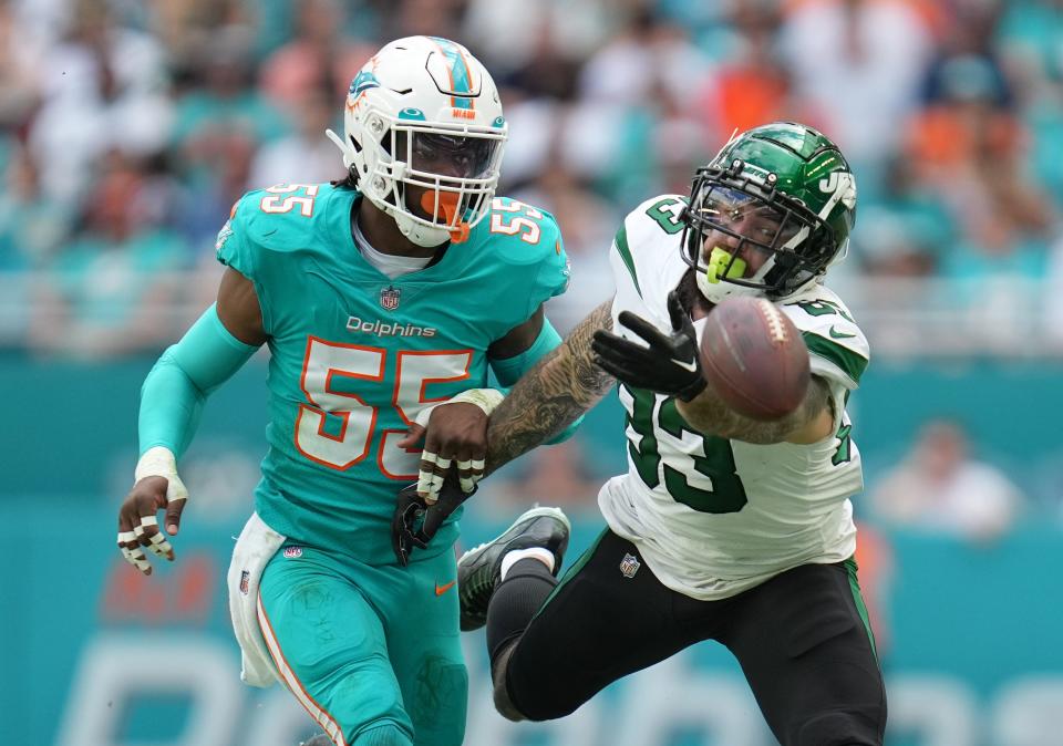 New York Jets tight end Tyler Conklin (83) reaches for a pass as Miami Dolphins linebacker Jerome Baker (55) covers on the play during the first half of an NFL game at Hard Rock Stadium in Miami Gardens, Jan. 8, 2023. 