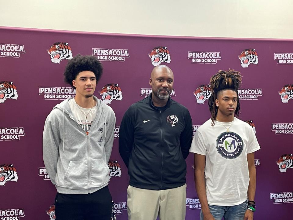Pensacola seniors Brian Harris (left) and Jonah Carter (right) stand along side Tigers boys basketball head coach Terrence Harris during a college signing ceremony on Thursday, April 13, 2023 at Pensacola High School.