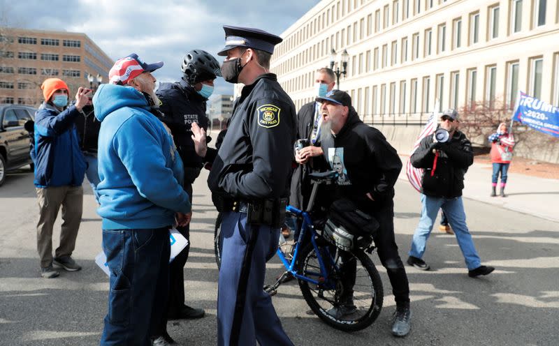 Michigan State Police separate a counter protestor from U.S. President Donald Trump's supporters as the Board of State Canvassers meet to certify the results of the election in Lansing