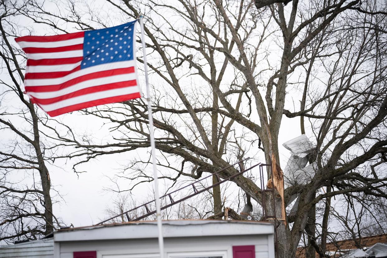 Siding hangs from tree branches behind a home in the Geiger Mobile Home Park. Two women residents there when homes were destroyed during a tornado that swept through the area.