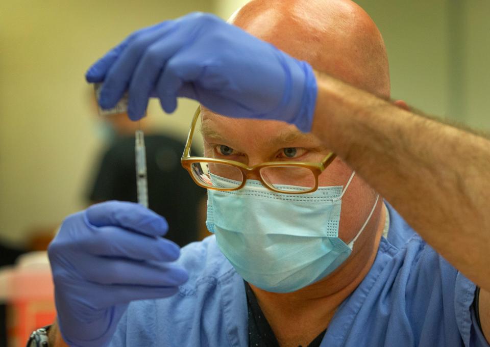 Registered nurse Ralph Jaszkowski draws a dose of vaccine for the coronavirus during a clinic at PeaceHealth Sacred Heart Medical Center at RiverBend in Springfield, Oregon.