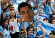 <p>Uruguay fan inside the stadium holds up a mask of Luis Suarez before the match </p>