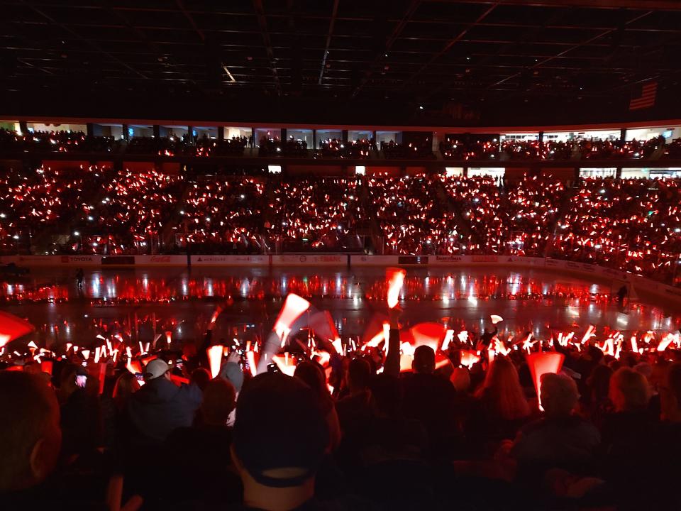 Firebirds fans wave glow sticks as the players are announced before the game.