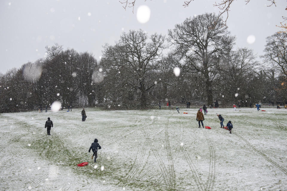 People enjoying the wintry weather at Darley Park, in Derby, central England, Tuesday Dec. 29, 2020.  Snow and ice brought treacherous conditions to many parts of the country overnight, with the cold snap forecast to bite into the new year. (Jacob King/PA via AP)