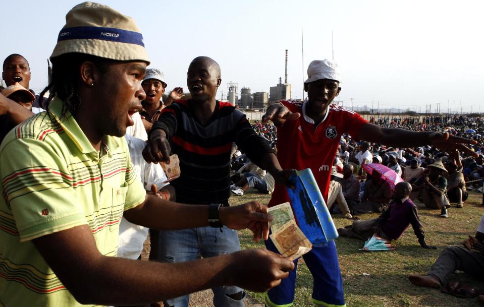 Miners sing and dance in Lonmin Platinum Mine near Rustenburg, South Africa, Tuesday, Sept. 18, 2012. Striking miners have accepted a company offer of a 22% overall pay increase to end more than five weeks of crippling and bloody industrial action. (AP Photo/Themba Hadebe)