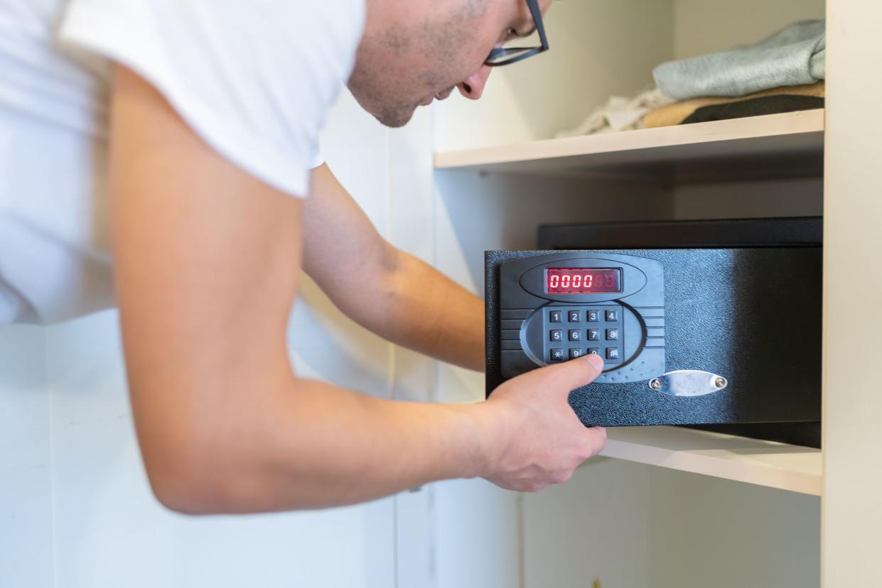 Man Using Safe In Hotel Room