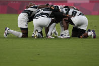 Fiji players kneel together as they react after winning gold over New Zealand in men's rugby sevens at the 2020 Summer Olympics, Wednesday, July 28, 2021 in Tokyo, Japan. (AP Photo/Shuji Kajiyama)