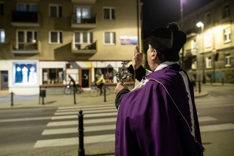 A priest Miroslaw Matuszny walks on the street holding Relics of St Anthony as he prays to stop spread of coronavirus (COVID-19) in Lublin