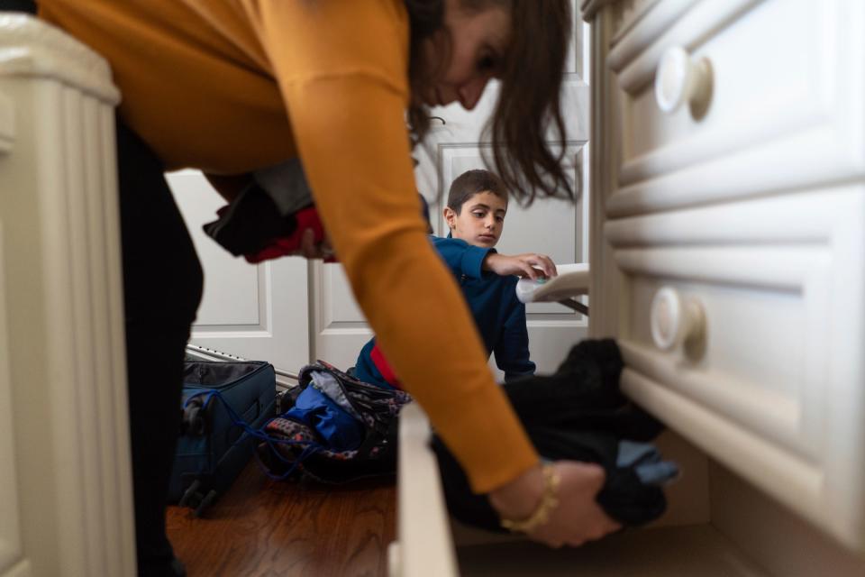 Palestine Children's Relief Fund Detroit chapter president Yasmeen Hamed unpacks clothing items for Saleh Humaid, 8, while hosting him at her home in Dearborn Heights on Tuesday, June 13, 2023. Humaid traveled to the U.S. with the help of the PCRF to receive free medical treatment and a new prosthetic leg along with rehab before returning home after losing part of his leg from shrapnel when a drone strike hit a car as he passed it while driving with his father in Gaza.