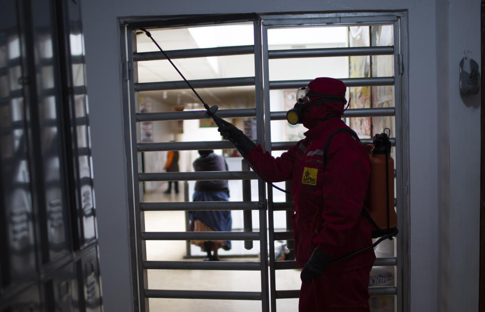 A city worker disinfects a public bathroom at the Camacho market as a preventative measure against the spread of the new coronavirus in La Paz, Bolivia, Friday, March 20, 2020. (AP Photo/Juan Karita