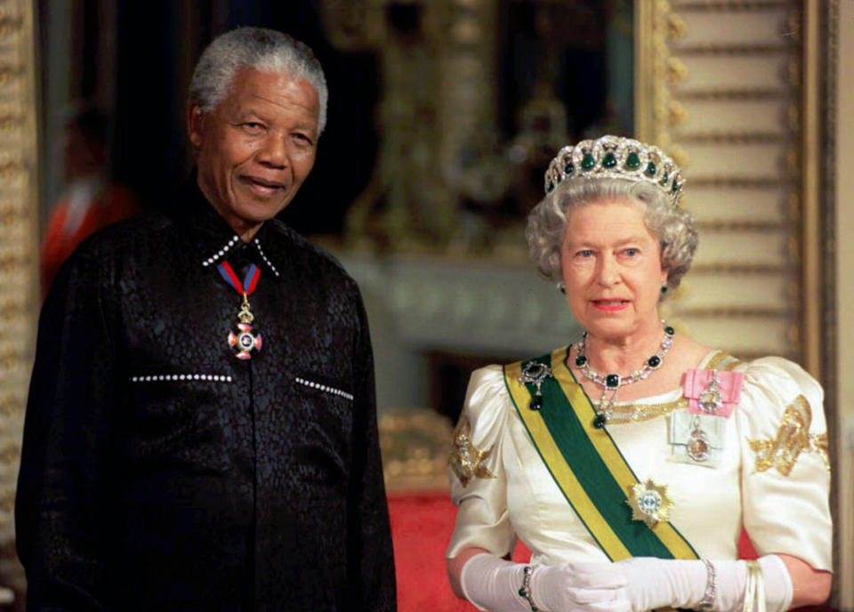 ARCHIVO - En esta fotografía de archivo del martes 9 de julio de 1996, el presidente de Sudáfrica, Nelson Mandela, con la reina Isabel II de Gran Bretaña a su llegada al Palacio de Buckingham, en Londres, para un banquete de Estado en honor de él. (Foto pool vía AP)