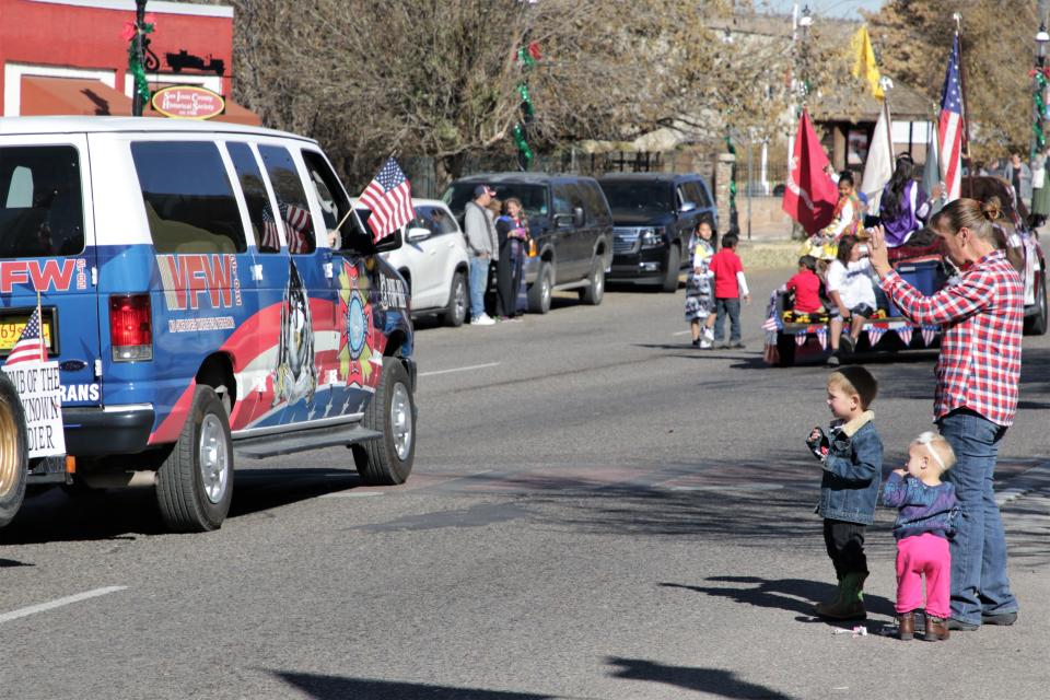 Jennie Wietharn-Yoakum and her son, Clayton, and daughter, Elaina, and wave to veterans during the Veterans Day Parade on Nov. 11, 2019 in Aztec.