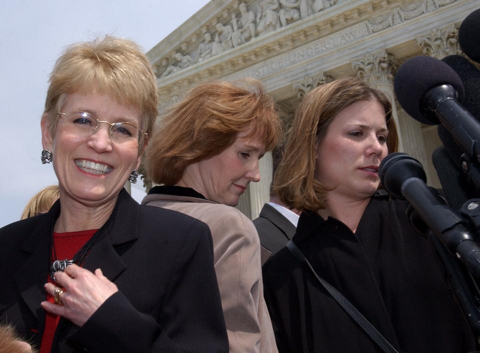 University of Michigan President Mary Sue Coleman, left, makes her way to the microphones past Barbara Grutter, center, and Jennifer Gratz, outside the Supreme Court in Washington, Tuesday, April 1, 2003. Supreme Court justices, confronting affirmative action in higher education for the first time since outlawing quotas 25 years ago, debated Tuesday whether colleges and universities may legally consider race when admitting students. Gratz and Grutter are plaintiffs in the affirmative action case againsthe University of Michigan. (AP Photo/Susan Walsh)