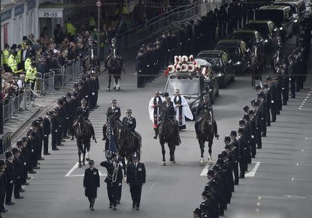 Police officers line the street as the coffin of PC Keith Palmer, who was killed in the recent Westminster attack, is transported from the Palace of Westminster, where it laid overnight, to his funeral at Southwark Cathedral in central London, Britain April 10, 2017. REUTERS/Hannah McKay