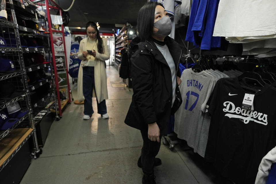 A customer shops around for goods related to Shohei Ohtani of the Los Angeles Dodgers for her father at SELECTION, a sporting goods store in Shinjuku district of Tokyo, Thursday, Feb. 29, 2024. (AP Photo/Hiro Komae)