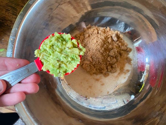 adding avocado to a bowl