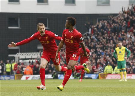 Liverpool's Raheem Sterling (C) celebrates his goal against Norwich City with teammate Lucas Leiva (L) during their English Premier League soccer match at Carrow Road in Norwich April 20, 2014. REUTERS/Stefan Wermuth