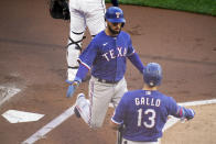 Texas Rangers' Isiah Kiner-Falefa, left, is greeted by Joey Gallo as he scores on a hit by Adolis Garcia in the first inning of a baseball game against the Minnesota Twins, Tuesday, May 4, 2021, in Minneapolis. (AP Photo/Jim Mone)