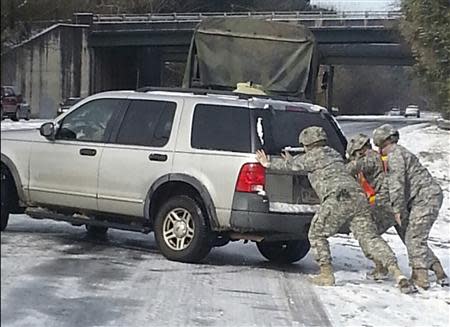 Georgia Army National Guard photo shows Staff Sgt. Andrew Huffman and soldiers of the Georgia National Guard's 48th Infantry Brigade Combat Team, 2nd Battalion 121st Infantry Company assisting stranded motorists following a rare ice storm in Atlanta, Georgia, January 29, 2014. Mandatory Credit: REUTERS/Andrew Huffman/Georgia Army National Guard photo/Handout via Reuters