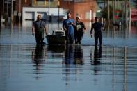 A family pulls a boat down a flooded street to their home to retrieve some belongings in the aftermath of Hurricane Matthew in Lumberton, North Carolina, U.S. October 12, 2016. REUTERS/Carlo Allegri