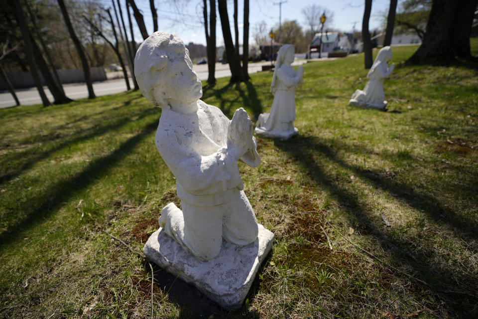 A statue of a praying boy is seen outside Holy Family Catholic Church, Friday, April 28, 2023, in Old Town, Maine. Robert Dupuis, of East Lyme, Conn., says he was abused as a boy at the church when it was known as St. Joseph Catholic Church. (AP Photo/Robert F. Bukaty)