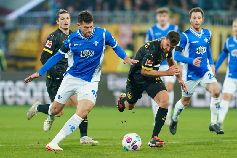 Darmstadt's Luca Pfeiffer (L) and Dortmund's Salih Oezcan battle for the ball during the German Bundesliga soccer match between Darmstadt 98 and Borussia Dortmund at Merck Stadium. Uwe Anspach/dpa