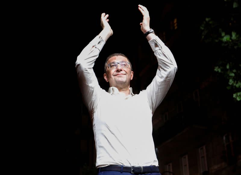 North Macedonian opposition party VMRO-DPMNE leader Hristijan Mickoski applauds as he addresses supporters following the parliamentary elections and second round of the presidential election in Skopje