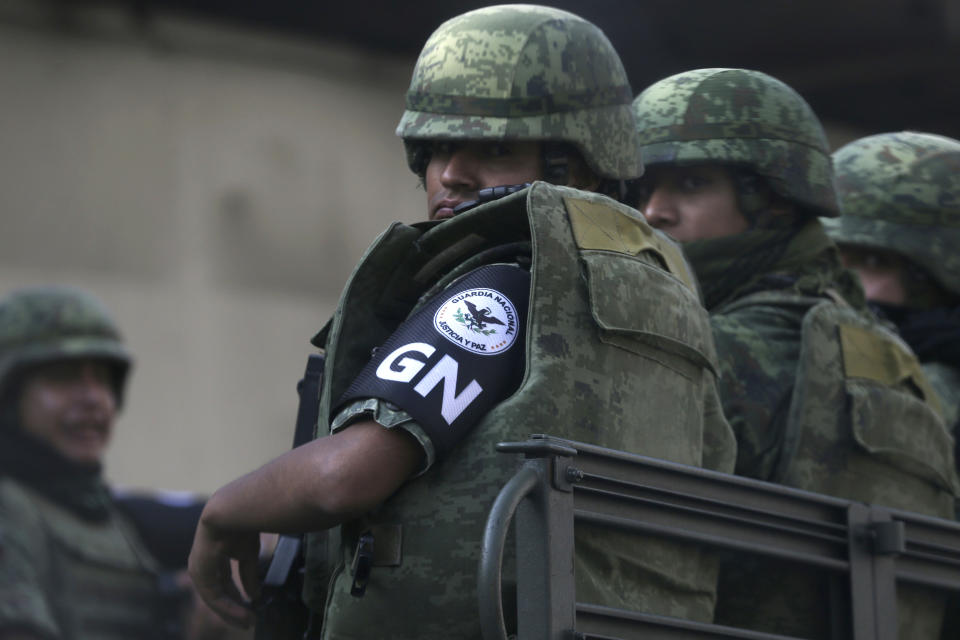 CORRECTS PRESENCE OF NATIONAL GUARD - Members of Mexico's newly-formed National Guard patrol near a federal police command center taken over by striking police in the Iztapalapa borough, in Mexico City, Thursday, July 4, 2019, who are protesting against plans to force them into the newly formed National Guard. Security Secretary Alfonso Durazo said the National Guard presence in Iztapalapa had nothing to do with the striking police. He said they had been deployed there to fight crime and were patrolling in the area. (AP Photo/Marco Ugarte)
