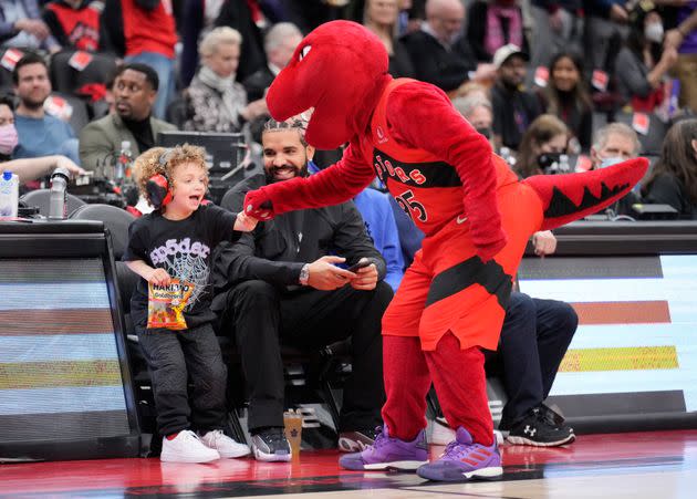 Drake, Adonis and the Raptors mascot at an April 7 game. (Photo: Mark Blinch via Getty Images)