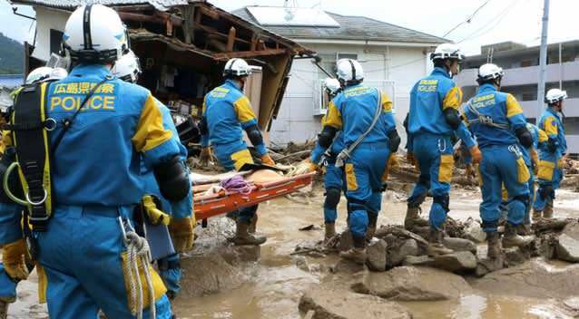 A troop of police rescue personnel head out for rescue operation after a massive landslides swept through residential area in Hiroshima, western Japan. Photo: AP