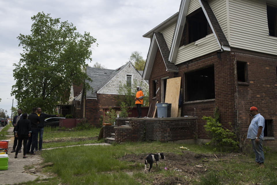 Crew members renovate an older home as members of the mayor’s office and the Detroit Housing and Revitalization office stand by. (Photo: Brittany Greeson for Yahoo News)