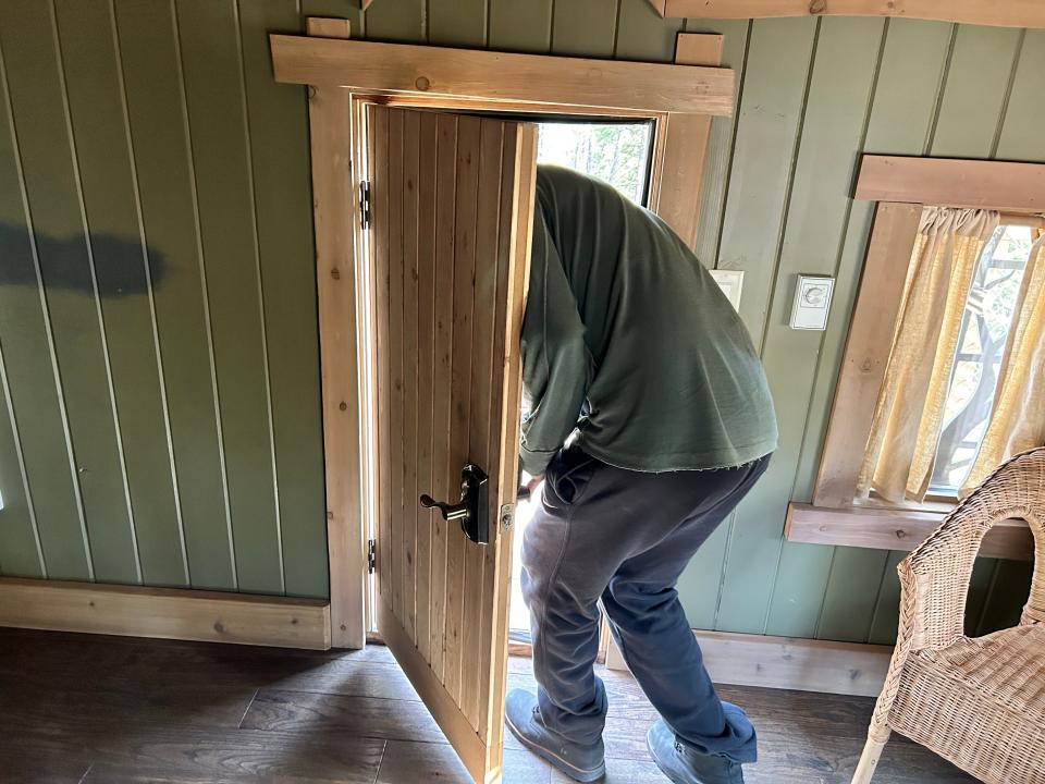 person going through tiny door on balcony