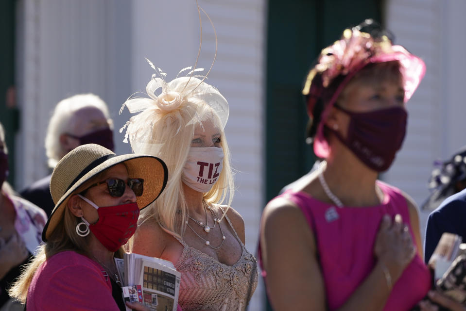 Guest of Kentucky Derby entry Tiz the Law stand during the national anthem before the 146th running of the Kentucky Derby at Churchill Downs, Saturday, Sept. 5, 2020, in Louisville, Ky. (AP Photo/Charlie Riedel)