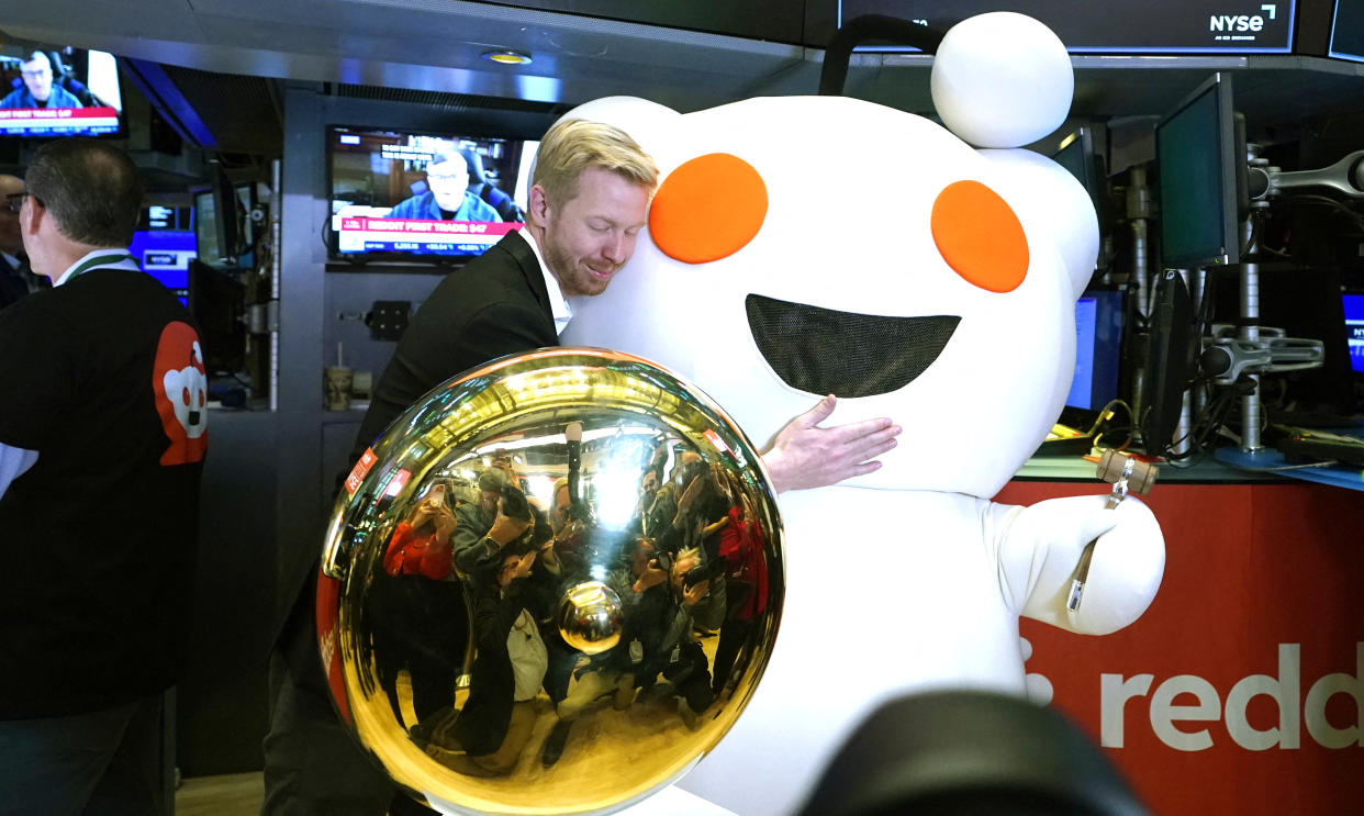 Reddit CEO Steve Huffman hugs mascot Snoo as Reddit begins trading on the New York Stock Exchange (NYSE) in New York on March 21, 2024. Shares of Reddit opened at $47 on the New York Stock Exchange Thursday before vaulting even higher in a buoyant market debut. Near 1720 GMT, Reddit shares stood at $56.60, up around 67 percent from their initial public offering price of $34. (Photo by TIMOTHY A. CLARY / AFP) (Photo by TIMOTHY A. CLARY/AFP via Getty Images)