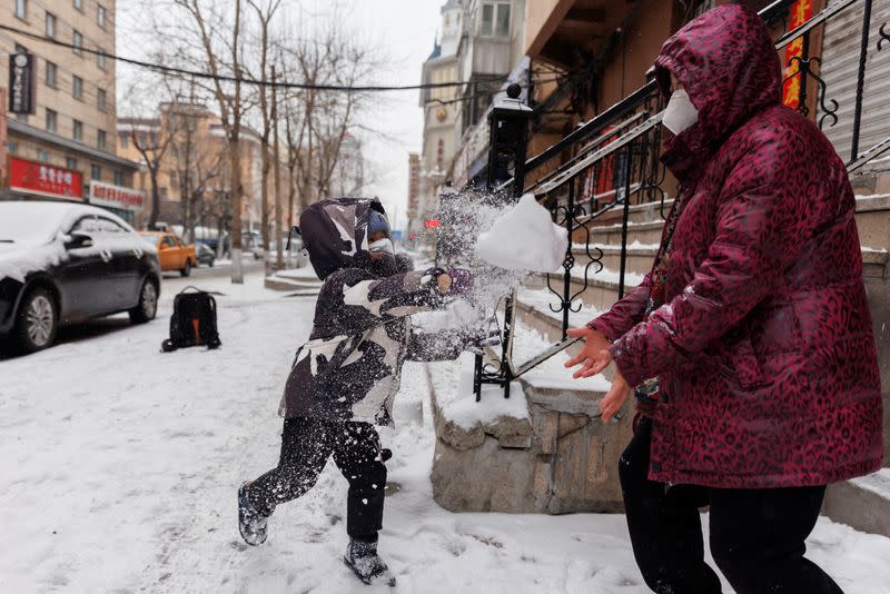 Pensioner Sunny Wang plays with her grandchild, in Harbin