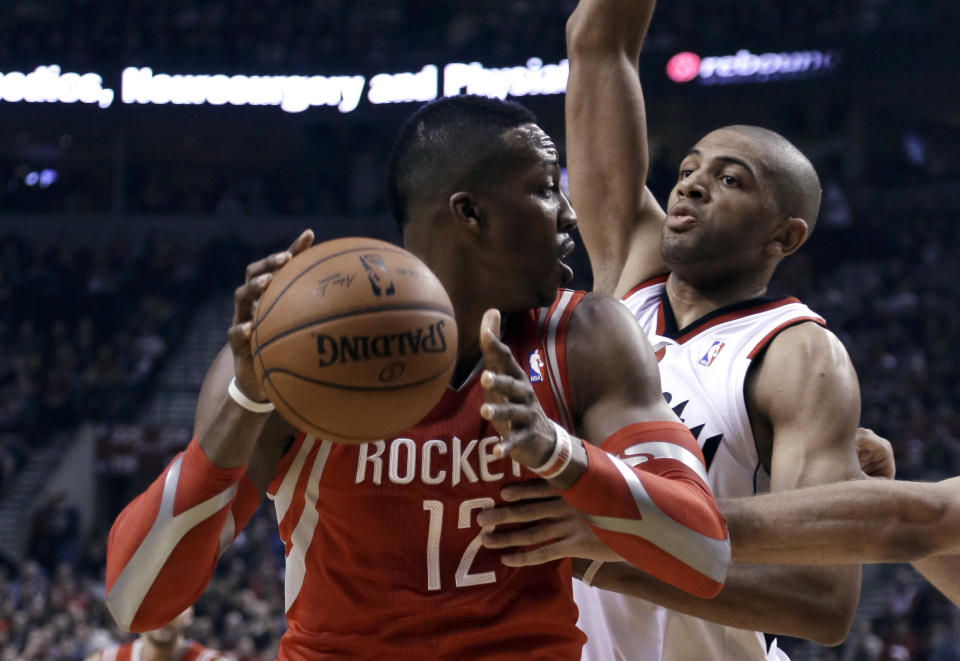 Houston Rockets center Dwight Howard, left, looks for an opening against Portland Trail Blazers forward Nicolas Batum during the first half of Game 3 of an NBA basketball first-round playoff series in Portland, Ore., Friday, April 25, 2014. (AP Photo/Don Ryan)
