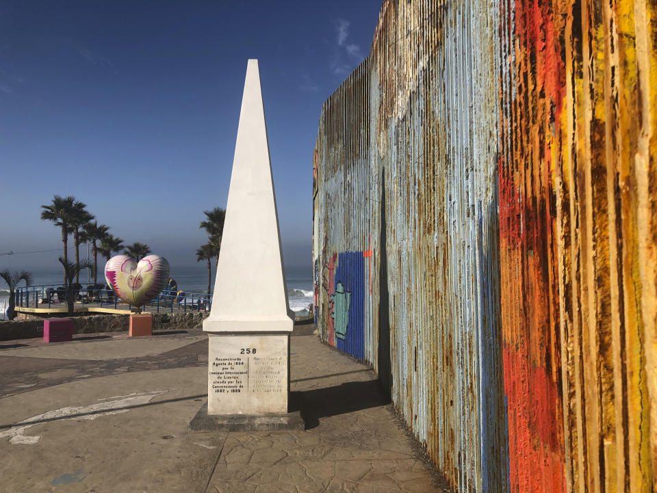 A white obelisk located on the Mexican side of a border marks the official international line between Mexico and the United States, Saturday, Jan. 25, 2020, in Tijuana, Mexico. The U.S. Border Patrol, reacting to a breach it discovered in a steel-pole border wall believed to be used by smugglers, gave activists no warning this month when it bulldozed the U.S. side of a cross-border garden on an iconic bluff overlooking the Pacific Ocean. On Saturday, after a public apology for "the unintentional destruction," the agency allowed the activists in a highly restricted area to resurrect the garden. (AP Photo/Elliot Spagat)
