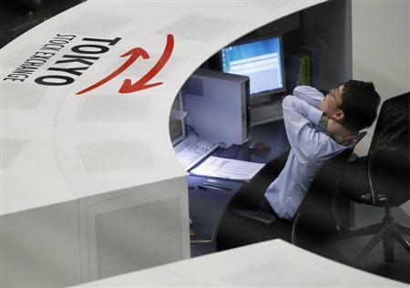 An employee of the Tokyo Stock Exchange (TSE) stretches at the bourse at the TSE in Tokyo April 11, 2014. REUTERS/Issei Kato