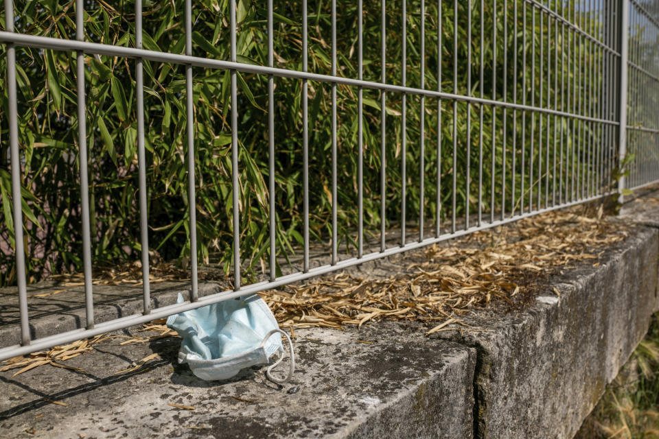 An abandoned mask is pictured in a garden Wednesday, June 16, 2021 in Paris. France on Wednesday eased several COVID-19 restrictions, with authorities saying it's no longer always mandatory to wear masks outdoors, and halting an 8-month nightly coronavirus curfew this weekend. (AP Photo/Benjamin Girette)