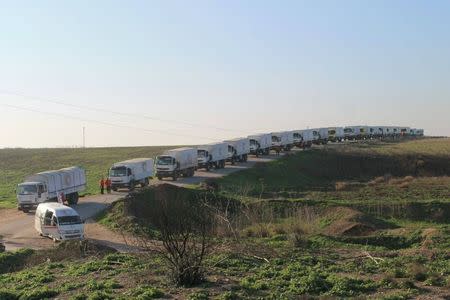 Aid trucks line a road before their departure for Damascus in this handout photo released February 17, 2016. REUTERS/Syrian Arab Red Crescent/Handout via Reuters