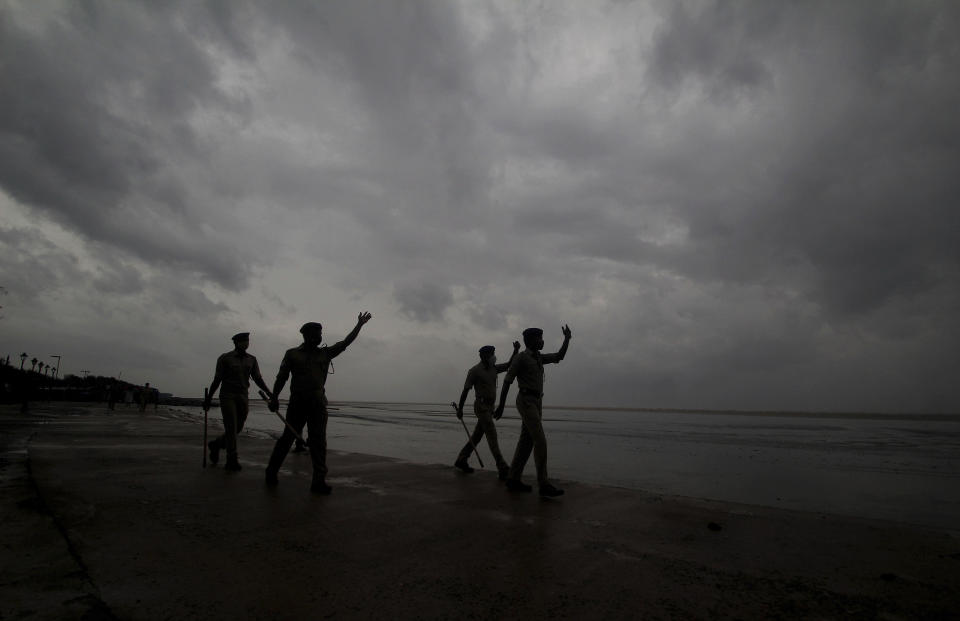 Policemen ask people to move to cyclone shelters as they patrol a beach in Balasore district in Odisha, India, Tuesday, May 25, 2021. Tens of thousands of people were evacuated Tuesday in low-lying areas of two Indian states and moved to cyclone shelters to escape a powerful storm barreling toward the eastern coast. (AP Photo)