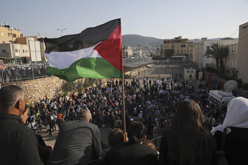 A Palestinian flag flies over the annual Land Day rally in the Arab city of Arraba, northern Israel, Tuesday, March 30, 2021. Land Day rallies by Palestinians protest what they say are discriminatory policies and to commemorate the deaths of six Arab protesters who were killed by police on March 30, 1976, while demonstrating against an Israeli plan to confiscate Arab land. (AP Photo/Mahmoud Illean)