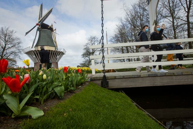 A couple wearing face masks take pictures at the world-famous Keukenhof garden in Lisse, Netherlands