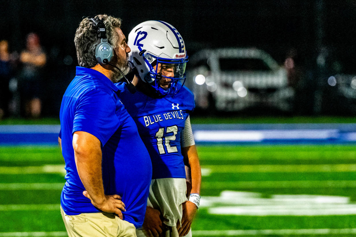 Fairhaven coach Derek Almeida gives the play call to his quarterback Jayce Duarte.